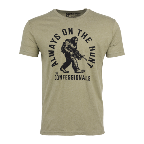 Light Olive tee with graphic of bigfoot holding gun with text "ALWAYS ON THE HUNT THE CONFESSIONALS"